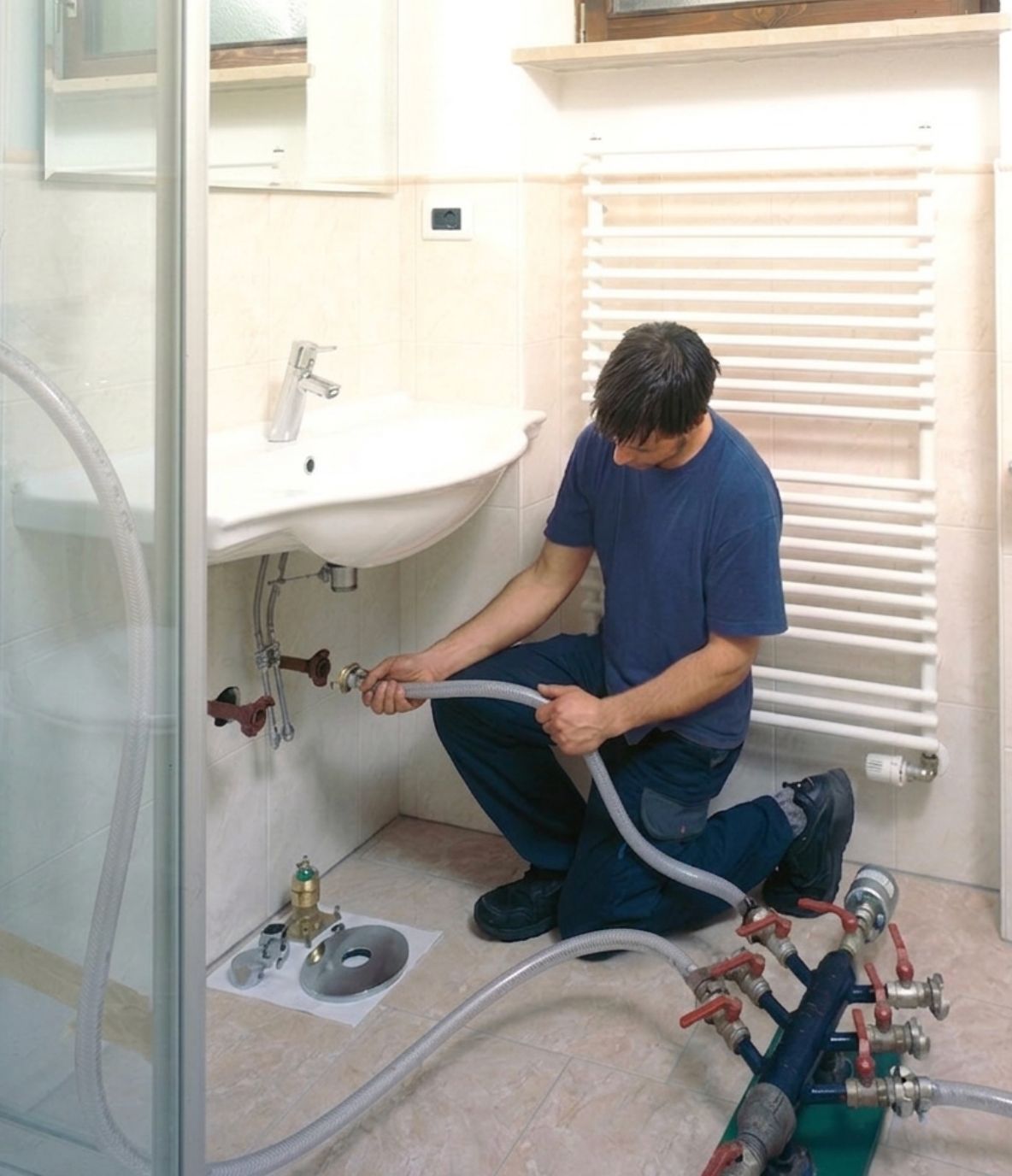 Installateur beim Anschluss von Wasserleitungen im Bad